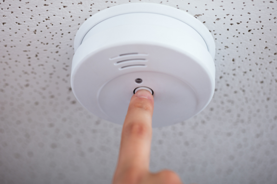 Fire alarm technician performing annual fire alarm testing and inspection in a commercial building