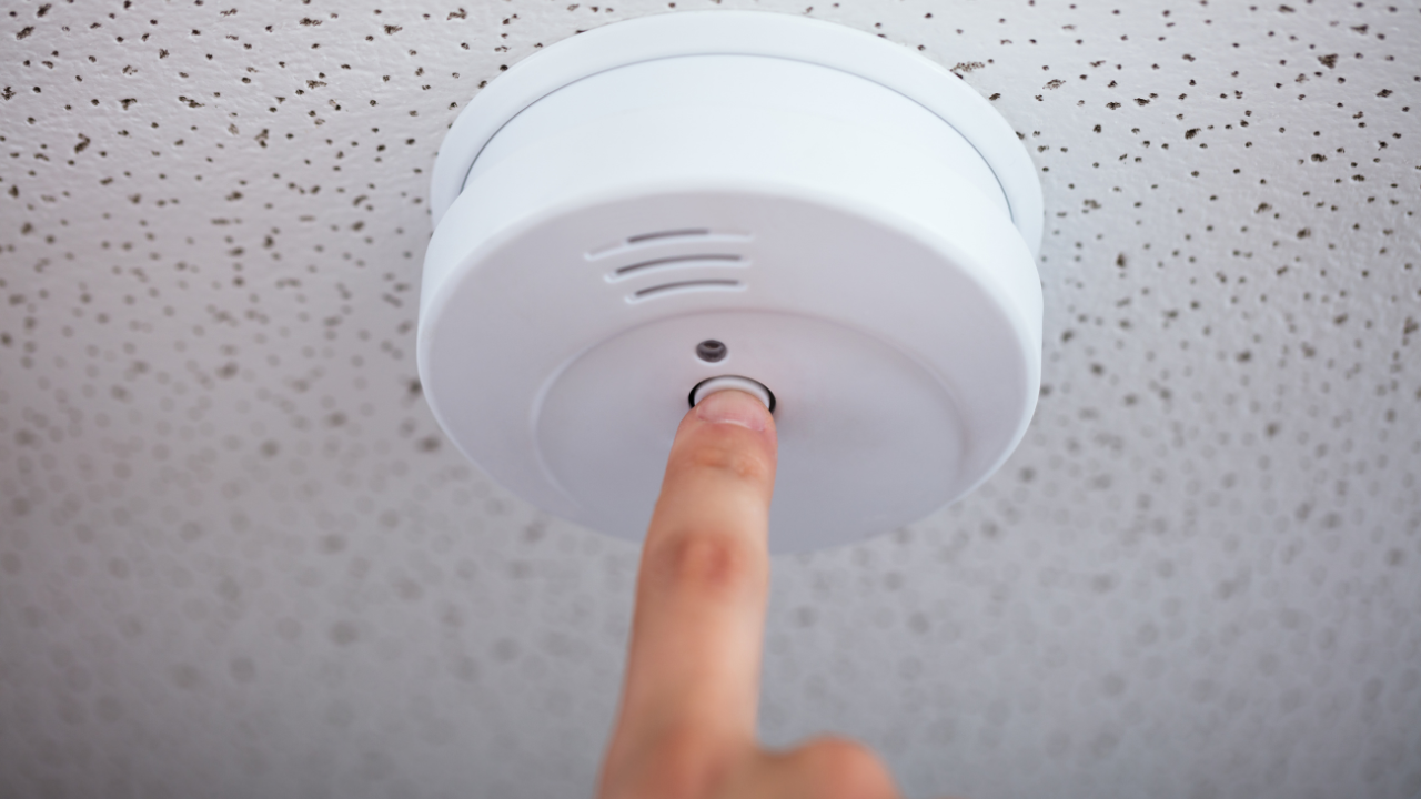 Fire alarm technician performing annual fire alarm testing and inspection in a commercial building